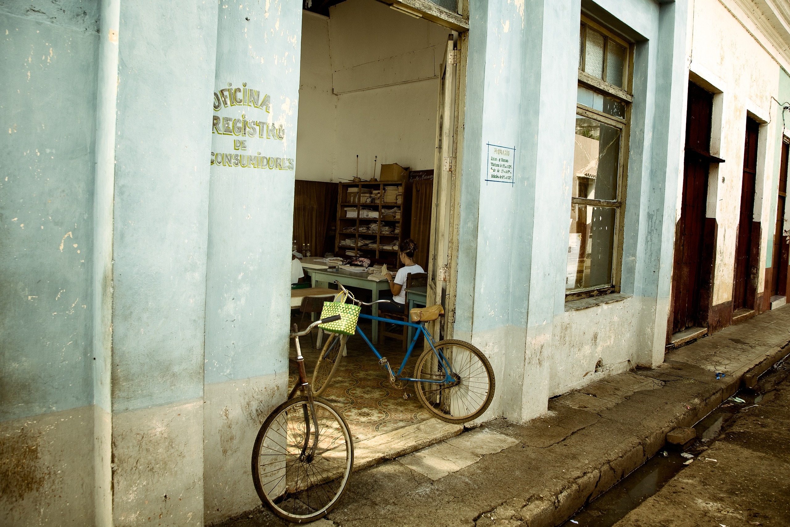 Vélo appuyé devant une boutique à la façade bleue, Caibarién, Villa Clara, Cuba