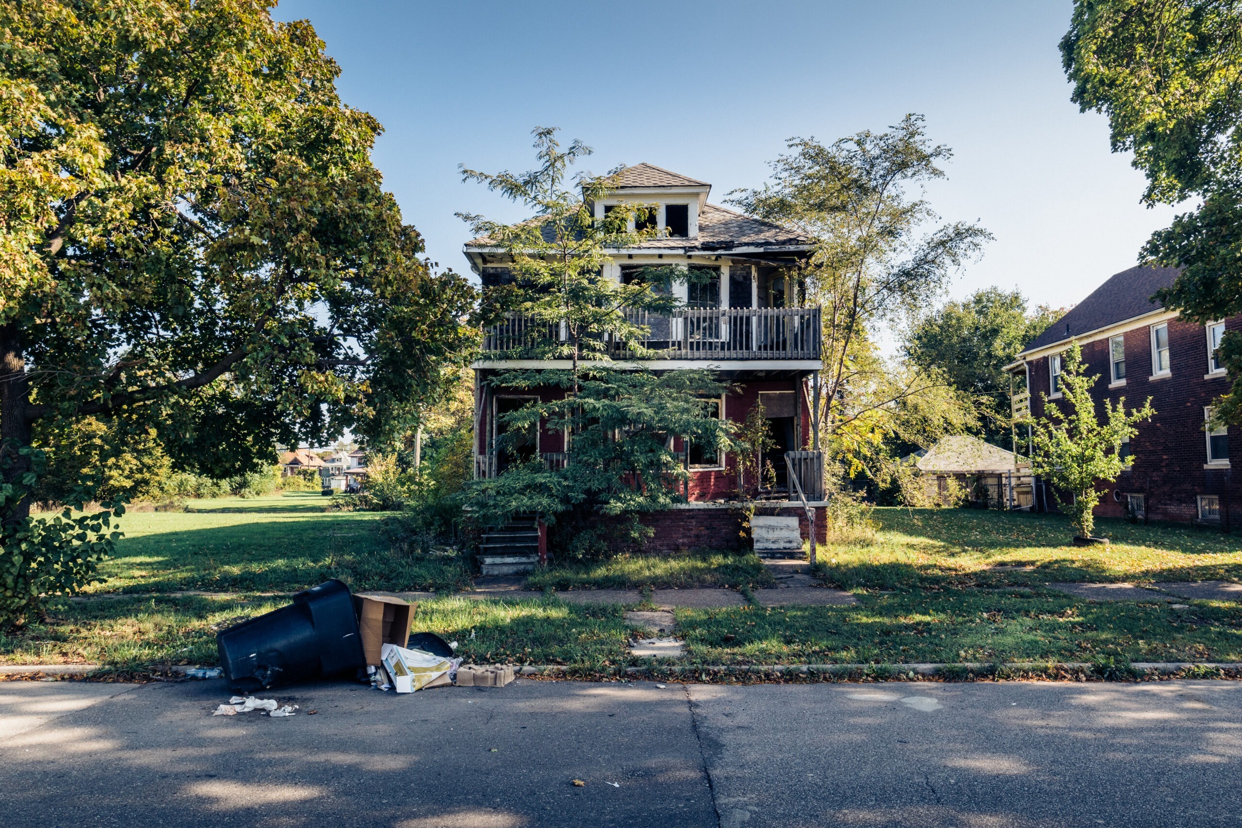 Maison à balcon avec une poubelle renversée devant, Detroit, Michigan