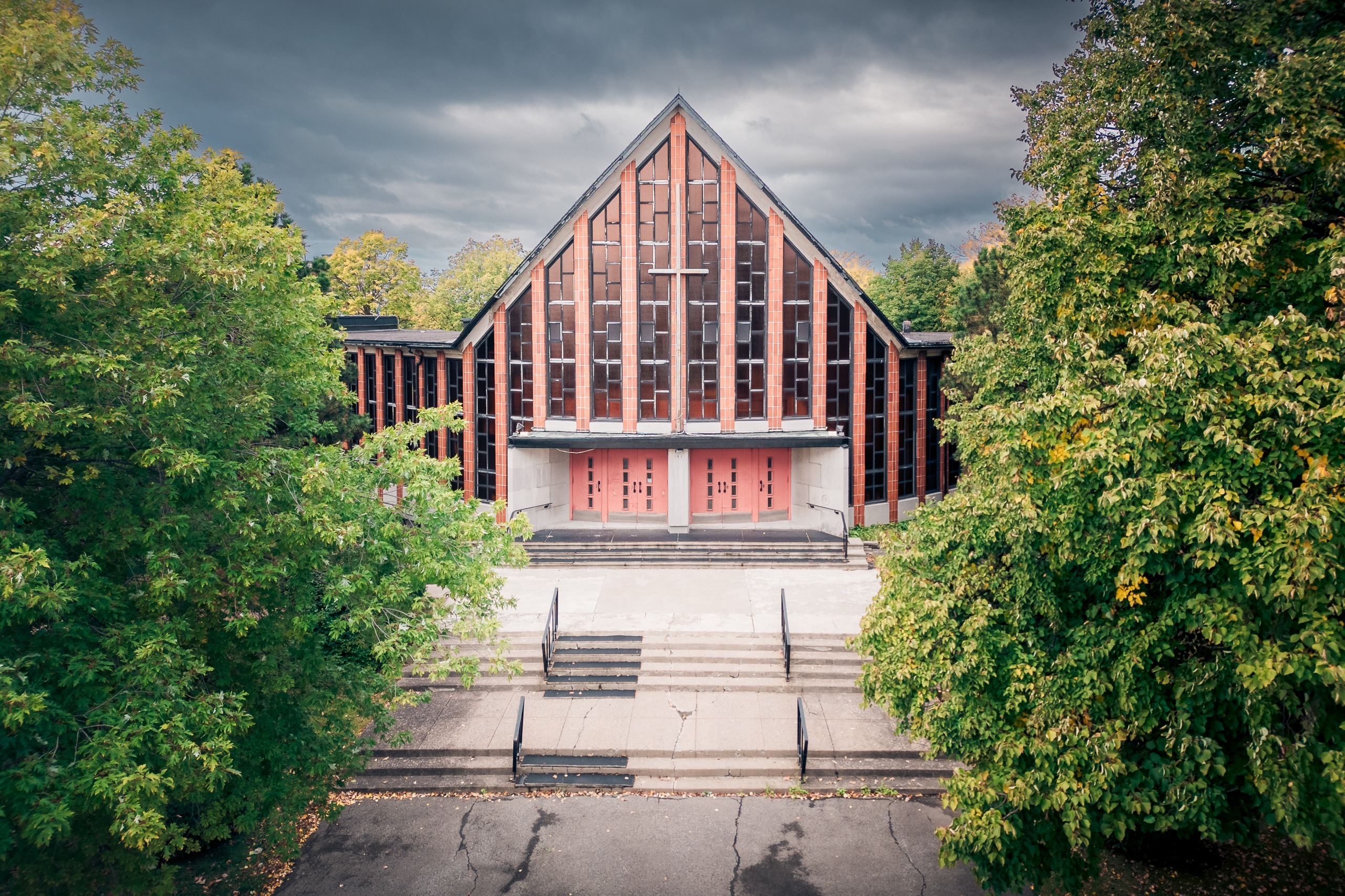 Façade d’une église moderniste et son escalier entre deux arbres, Ahuntsic, Montréal