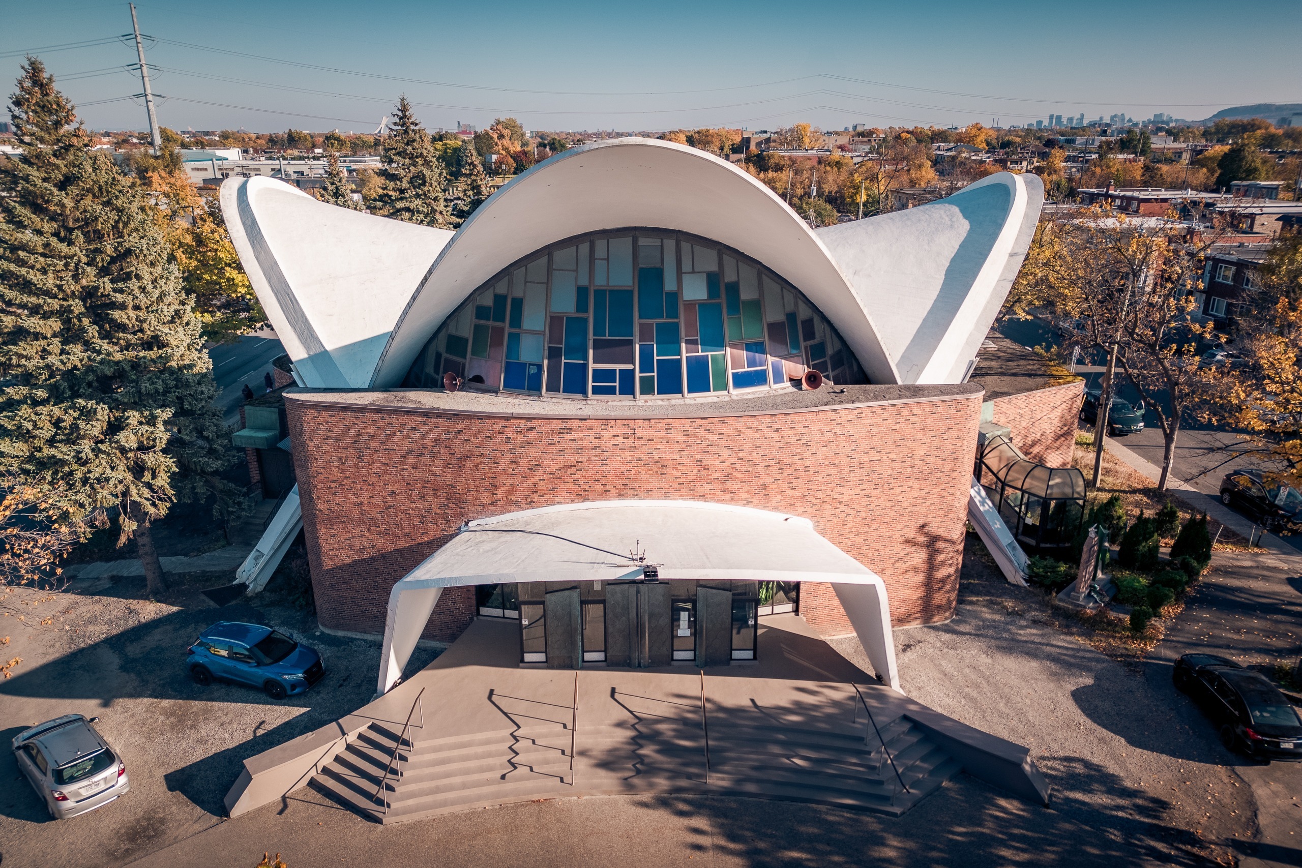 Façade de brique, voûte blanche et vitraux d’une église moderniste, Ahuntsic, Montréal