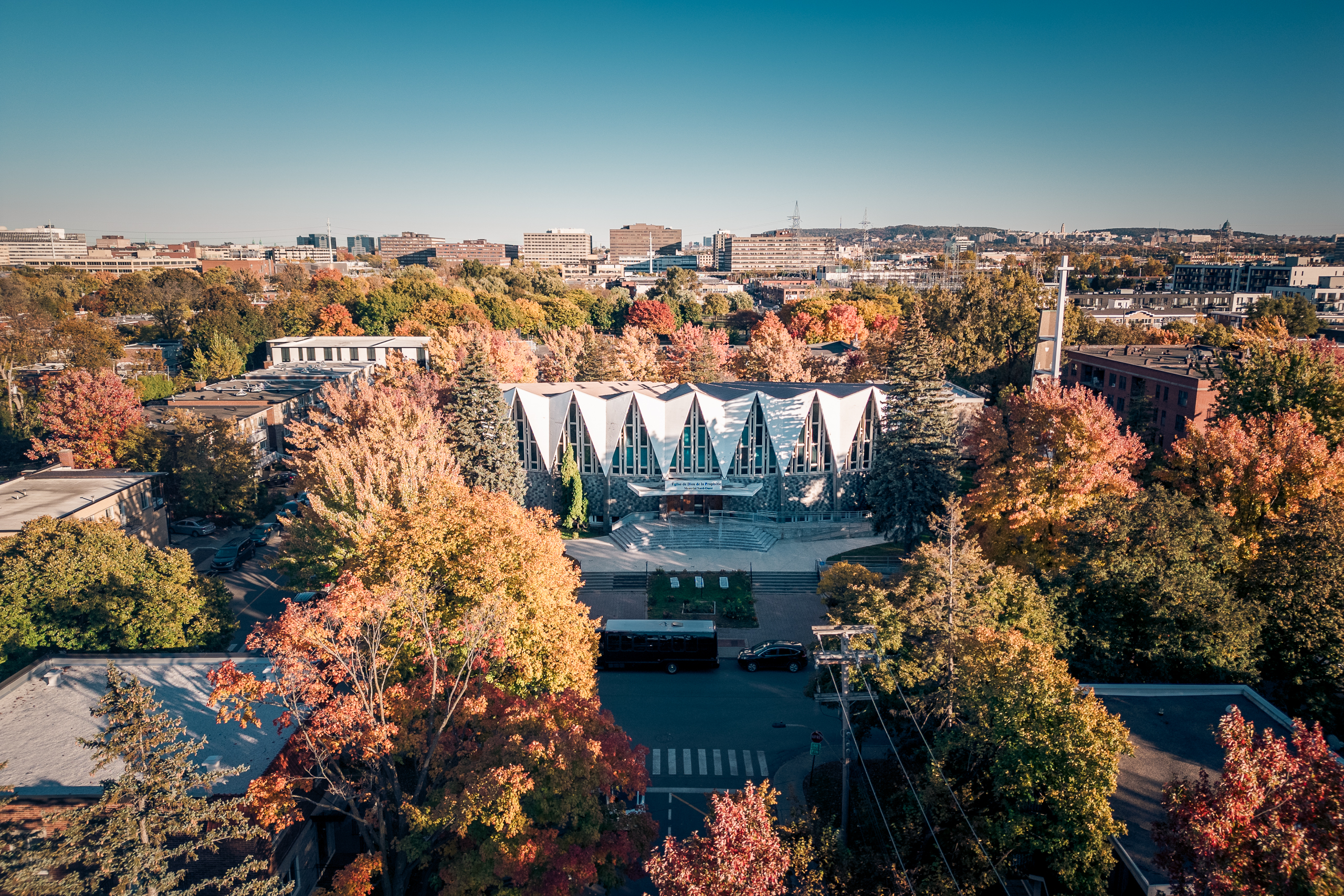Église au toit plissé blanc entourée d’arbres d’automne, vue aérienne, Ahuntsic, Montréal