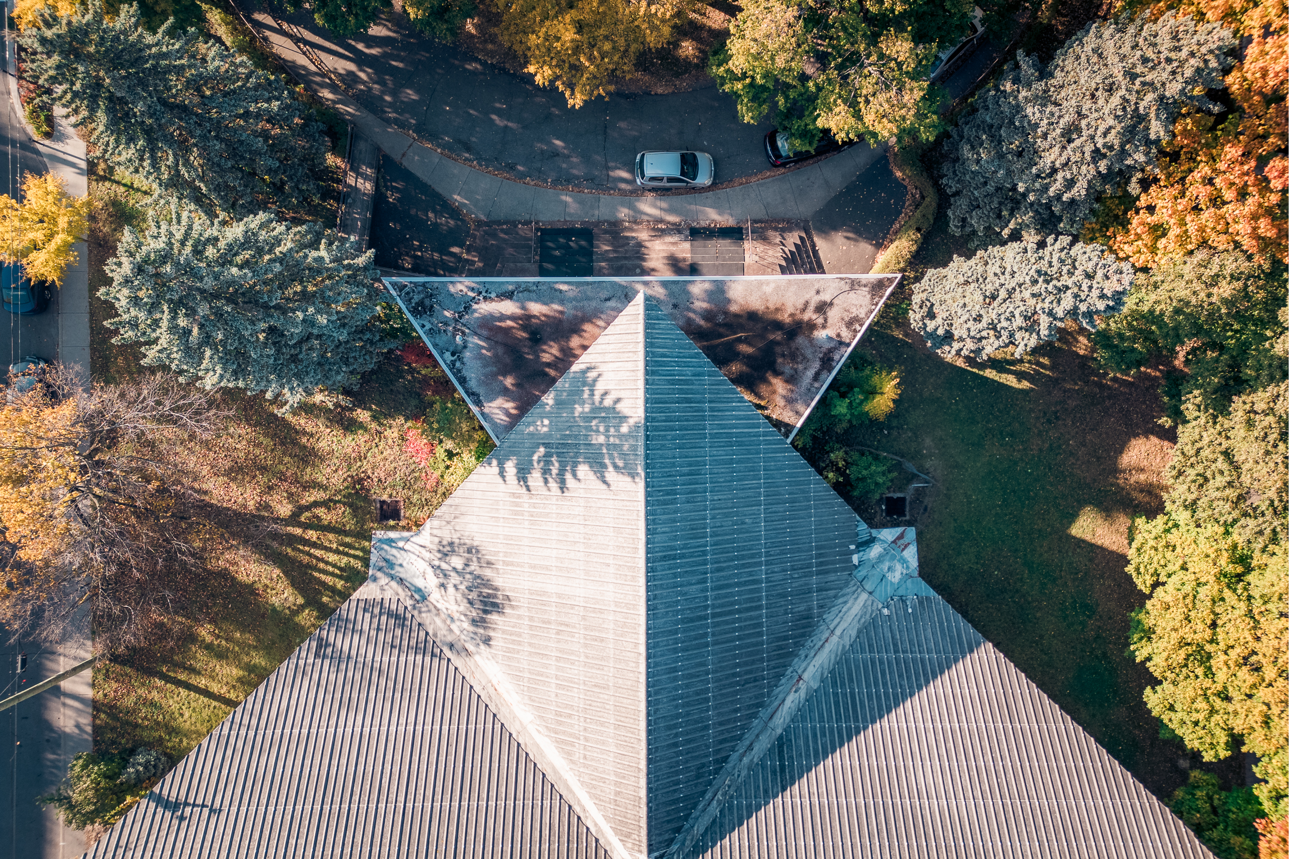 Toit triangulaire d’une église moderniste vu du dessus, arbres d’automne, Ahuntsic, Montréal