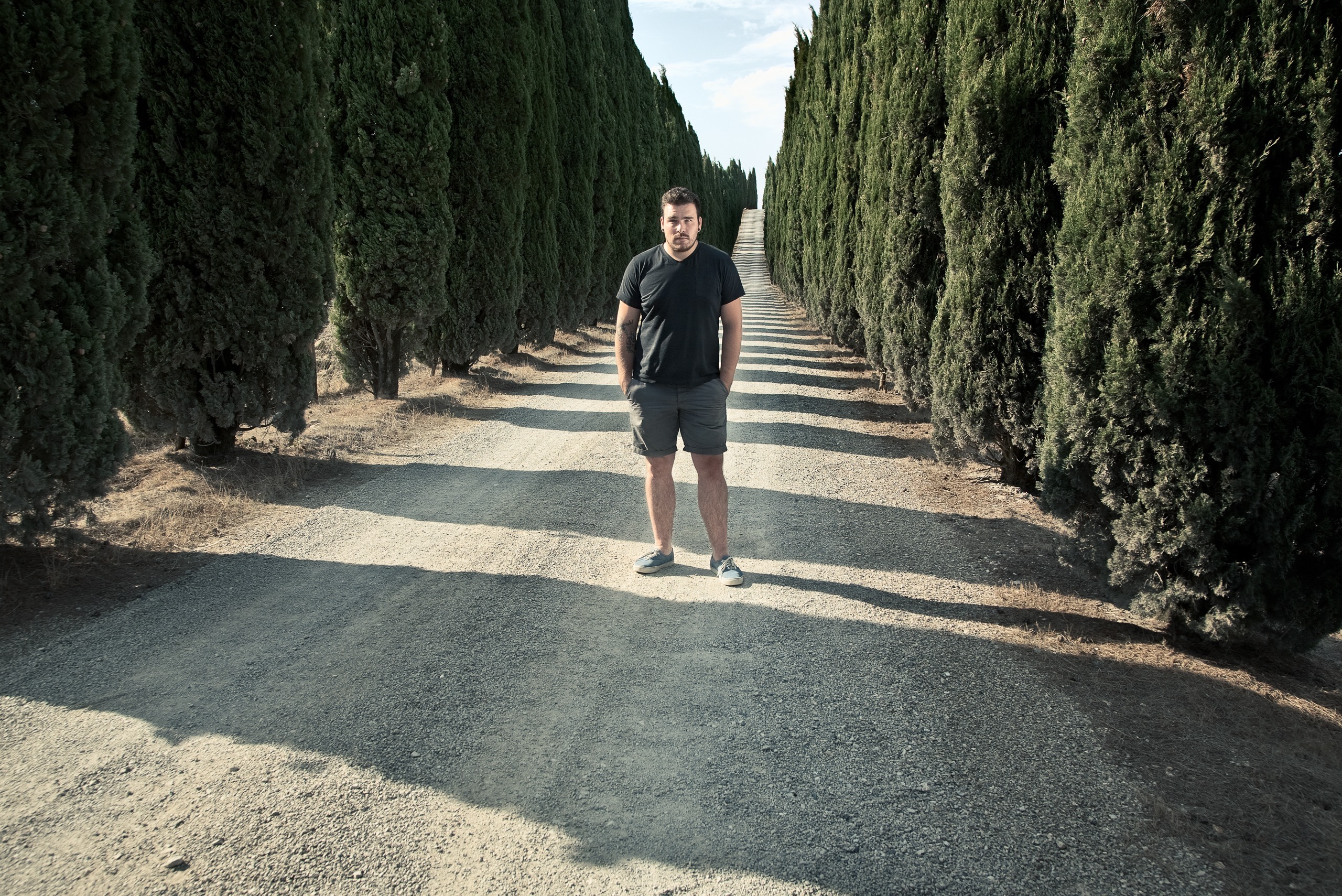 Portrait au milieu d’une allée bordée de cyprès