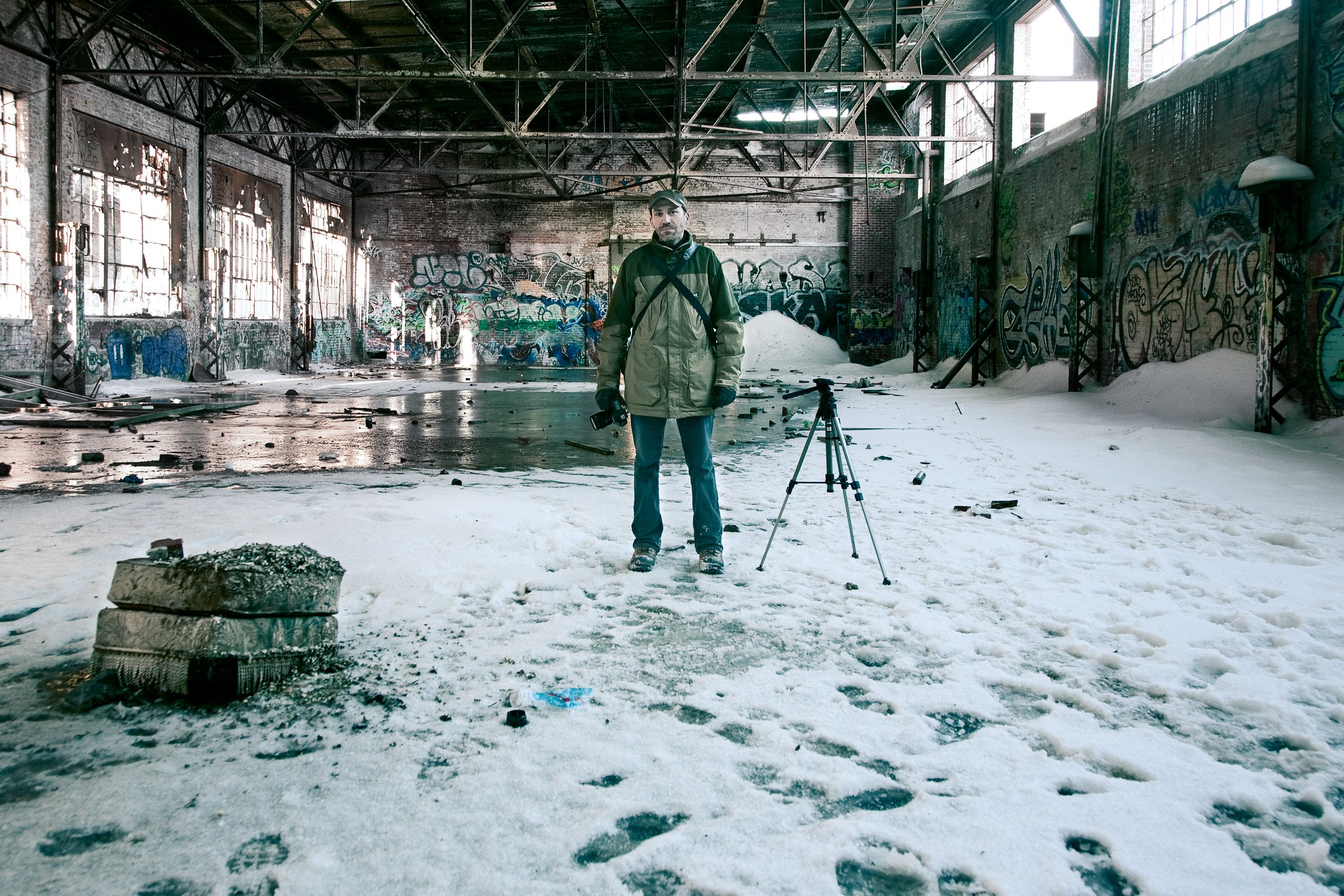 Portrait dans une usine abandonnée sous la neige, avec un trépied