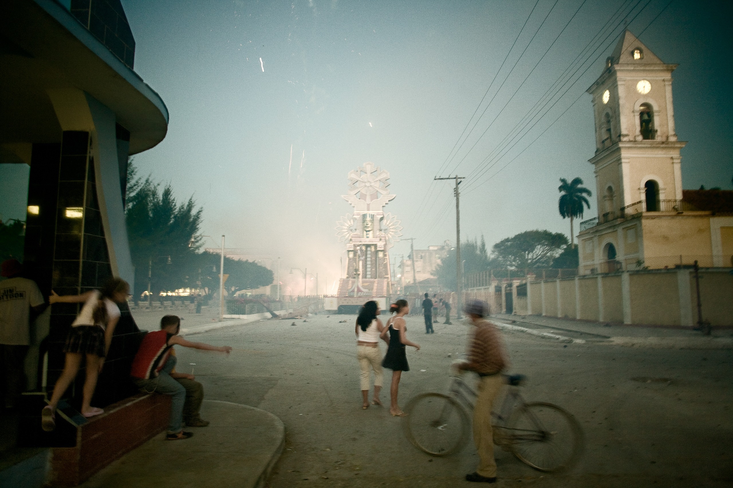 Rue de Remedios à la tombée du jour, cyclistes devant un clocher, Villa Clara, Cuba