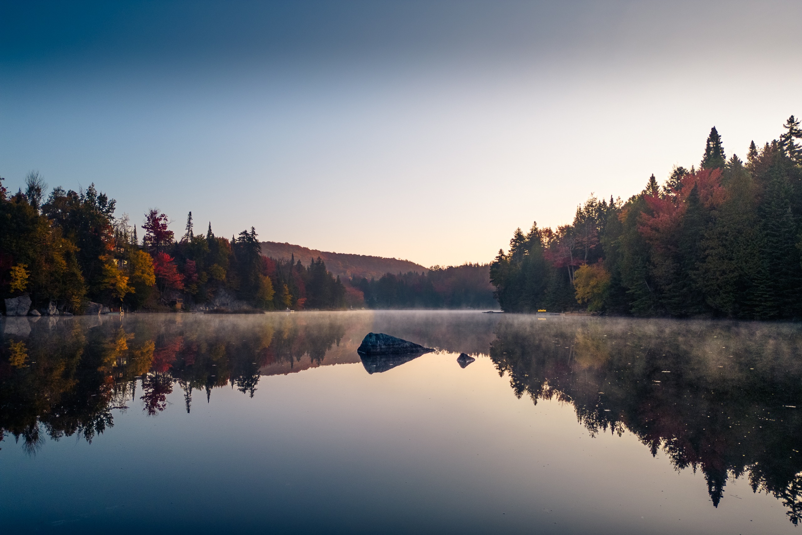 Lac calme à l’aube, forêt d’automne reflétée dans l’eau, Saint-Adolphe-d’Howard, Laurentides