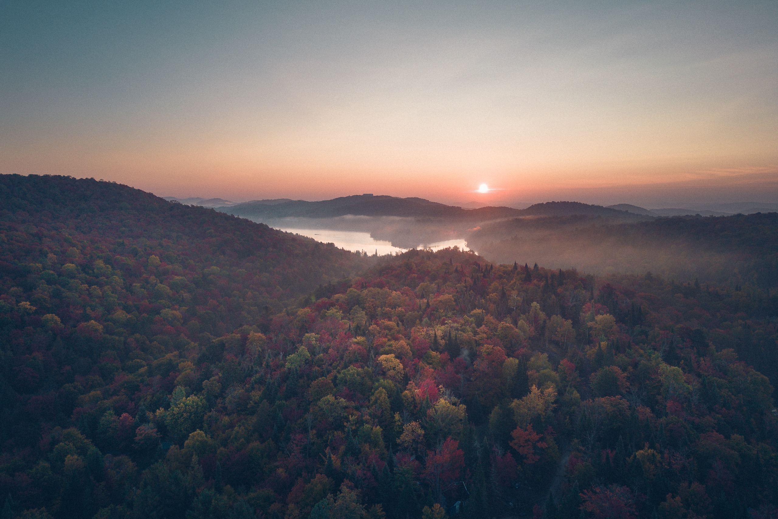 Soleil levant et brume au-dessus de collines boisées, Saint-Adolphe-d’Howard, Laurentides
