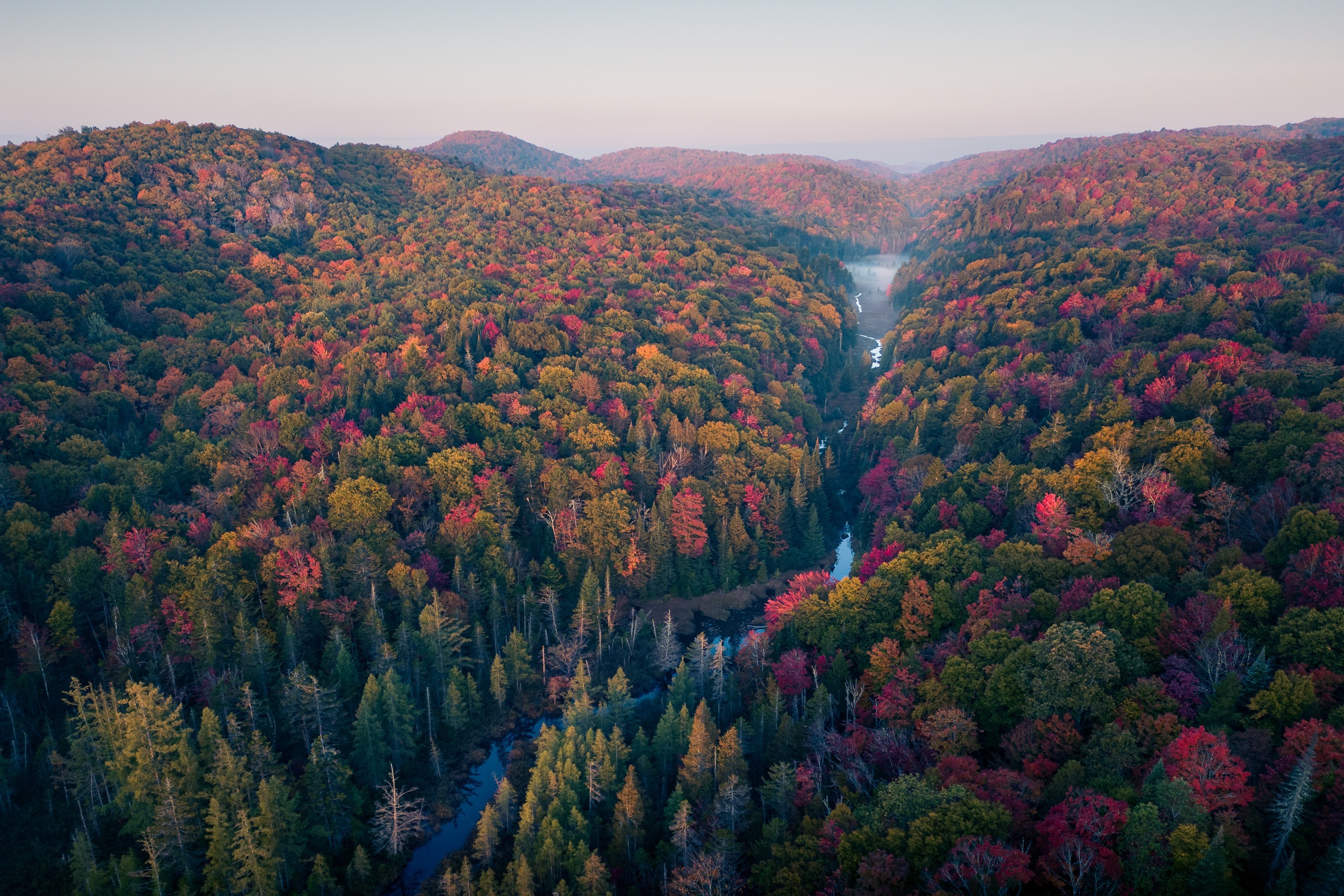 Vue aérienne d’une vallée boisée aux couleurs d’automne et d’une rivière, Saint-Adolphe-d’Howard, Laurentides
