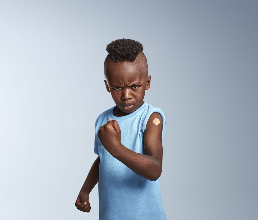 Grimace d’un enfant au poing levé, pansement sur le bras, campagne Tiens-toi bien, COVID-19, Gouvernement du Québec