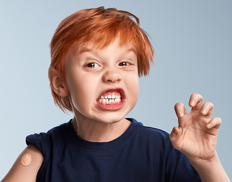 Grimace féroce d’un enfant roux qui fait la griffe, pansement sur le bras, campagne Tiens-toi bien, COVID-19, Gouvernement du Québec