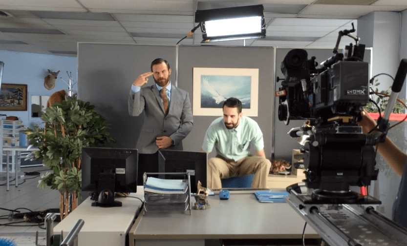 Plateau de tournage dans un bureau : caméra et deux hommes, campagne #approved4work de Virgin Radio